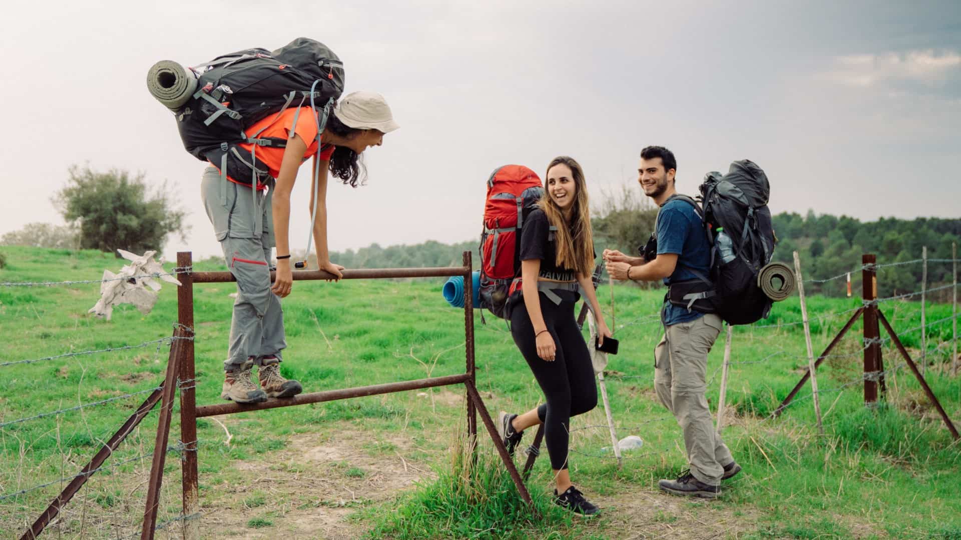 Friends backpacking in field